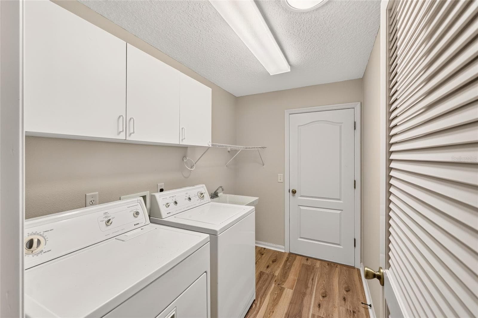 Indoor Laundry Room has cabinets and LVP - 17101 SE 94TH BERRIEN CT, THE VILLAGES