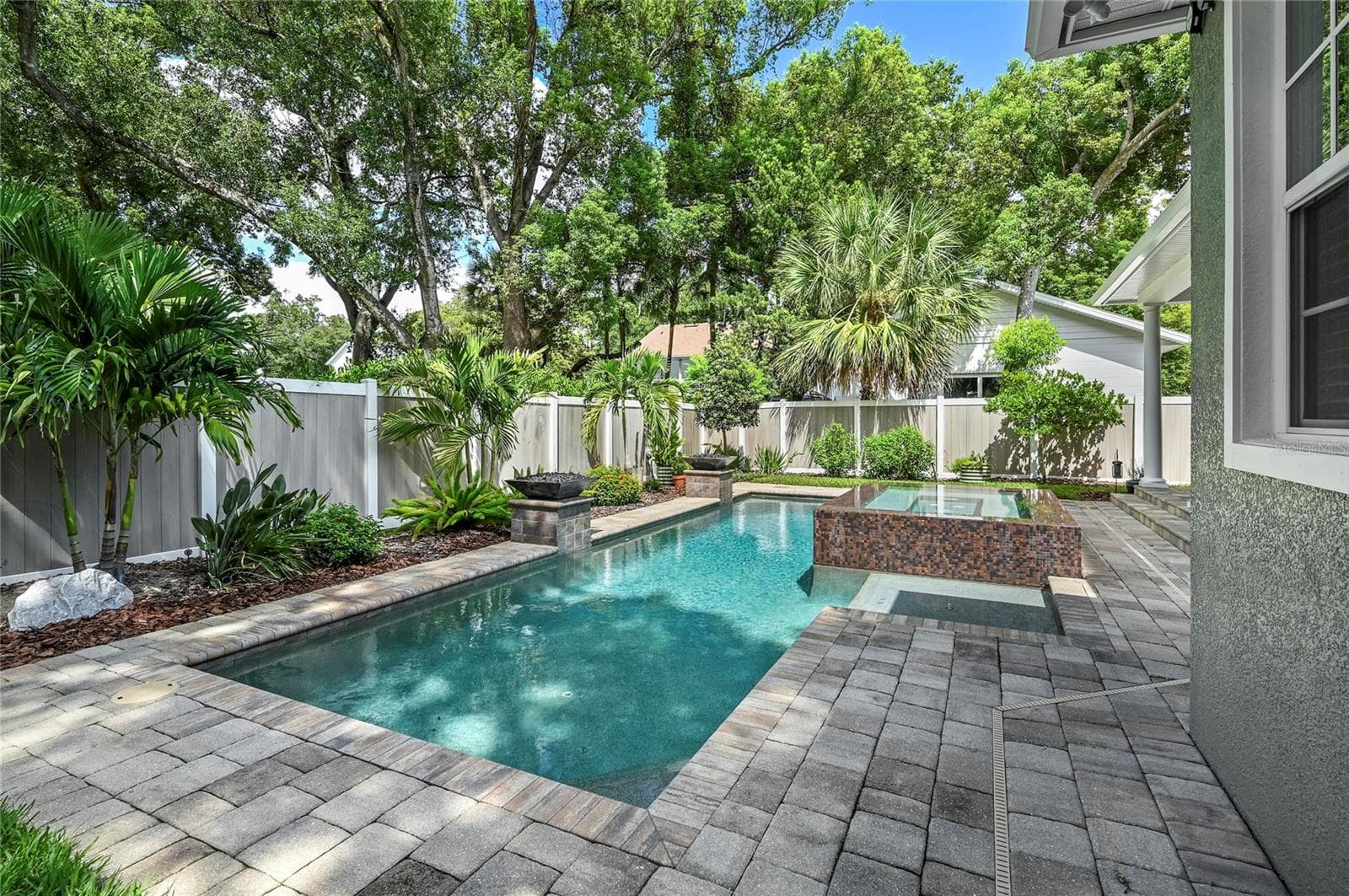 The back of the home looks out to beautiful skies and a towering tree canopy. - 1951 WINTER PARK RD, WINTER PARK