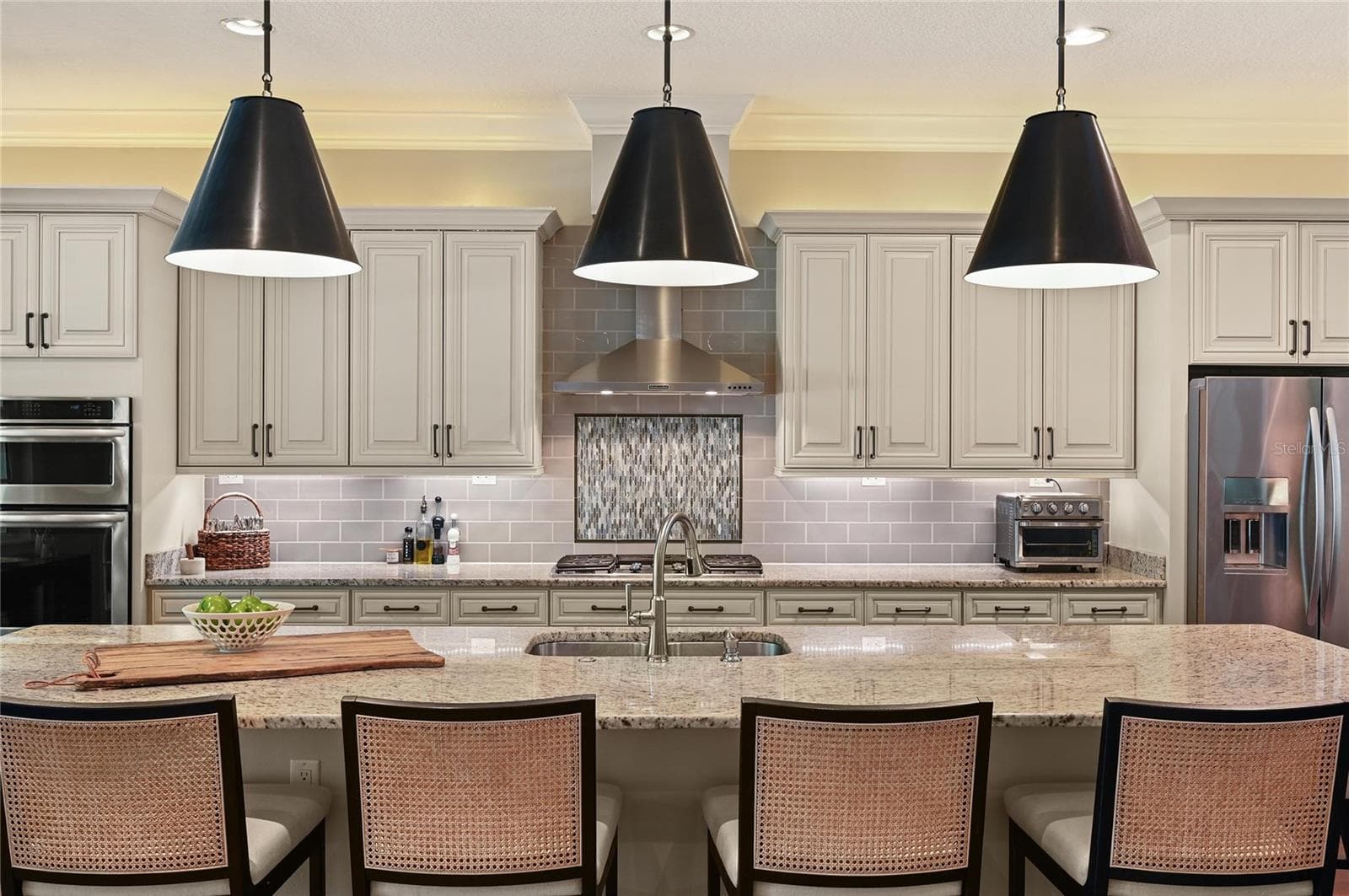 Pendant lights give a sense of warmth and highlight the beauty of the stone counter top. - 1951 WINTER PARK RD, WINTER PARK