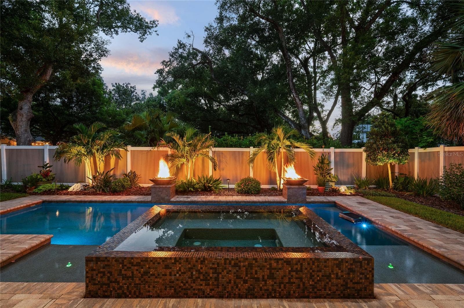 Twilight is magical overlooking the spill-over spa with gas firepits. - 1951 WINTER PARK RD, WINTER PARK