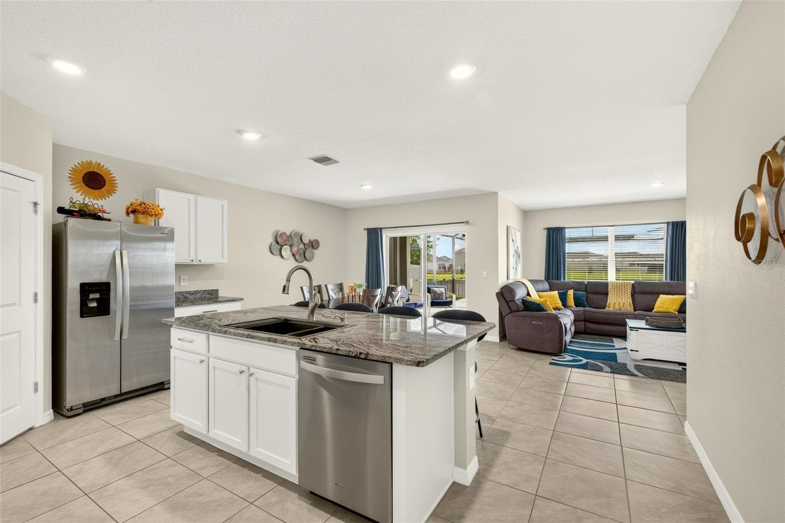 The heart of the home; bright, open kitchen with large center island and snack bar - 17206 RESERVA DR, BRADENTON