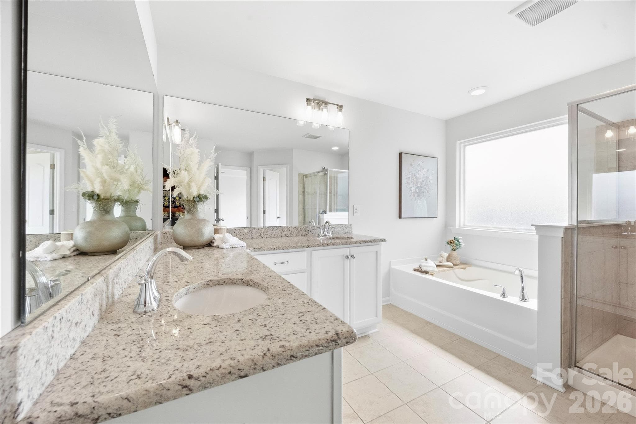 Spacious primary bath features dual vanities, a soaking tub, and separate walk-in shower - 2015 Kensley Drive, Waxhaw