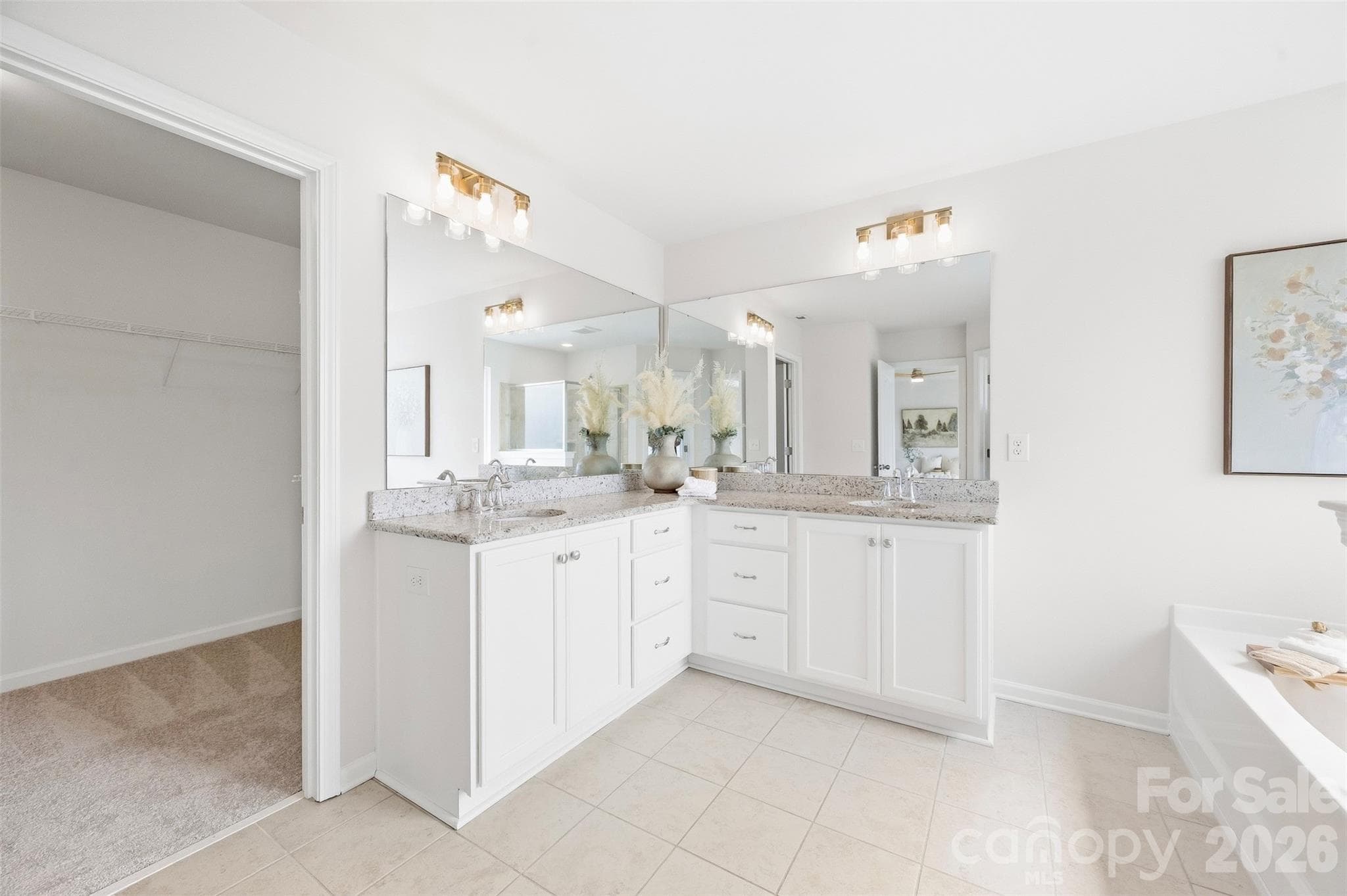 A spacious primary bath designed to impress with dual vanities, abundant storage, a soaking tub, separate shower, new lighting, and fixtures - 2015 Kensley Drive, Waxhaw
