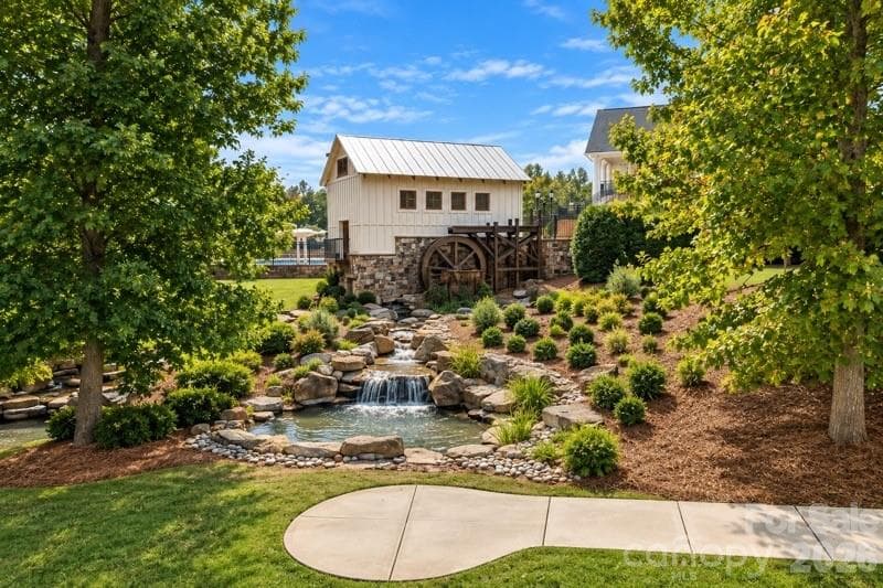 The iconic MillBridge water wheel, surrounded by cascading water and lush landscaping, reflects the distinctive character of this award-winning community - 2015 Kensley Drive, Waxhaw