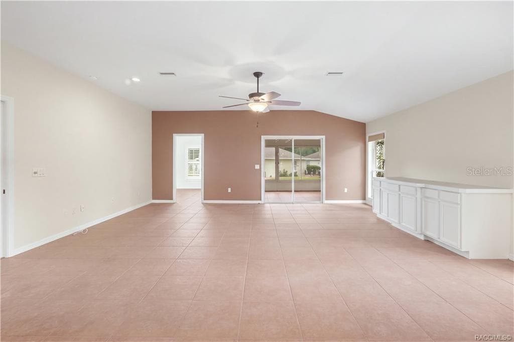 Living Room – Generously sized main living area with expansive tile flooring, ceiling fan & plenty of room to create multiple conversation or entertainment areas. Sliding glass doors extend the towards the Florida room and flex room /4th bedroom. - 6410 W CANNONDALE DR, CRYSTAL RIVER