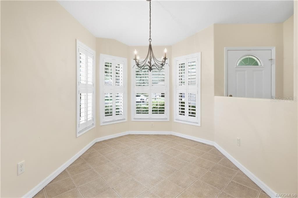 Kitchen Nook Light-filled dining area featuring diagonal-set tile flooring, a decorative chandelier & an impressive grouping of windows finished with plantation shutters—an inviting setting for everything from morning coffee to dinner with friends. - 6410 W CANNONDALE DR, CRYSTAL RIVER