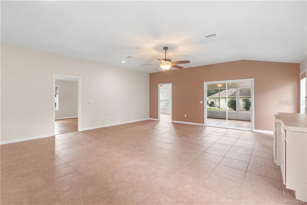 Living Room / FLORIDA ROOM VIEW – Another angle showcases the width of the main living space and its easy connection to adjoining rooms. Sliding glass doors bring in additional natural light while providing direct access to the Florida room. - 6410 W CANNONDALE DR, CRYSTAL RIVER