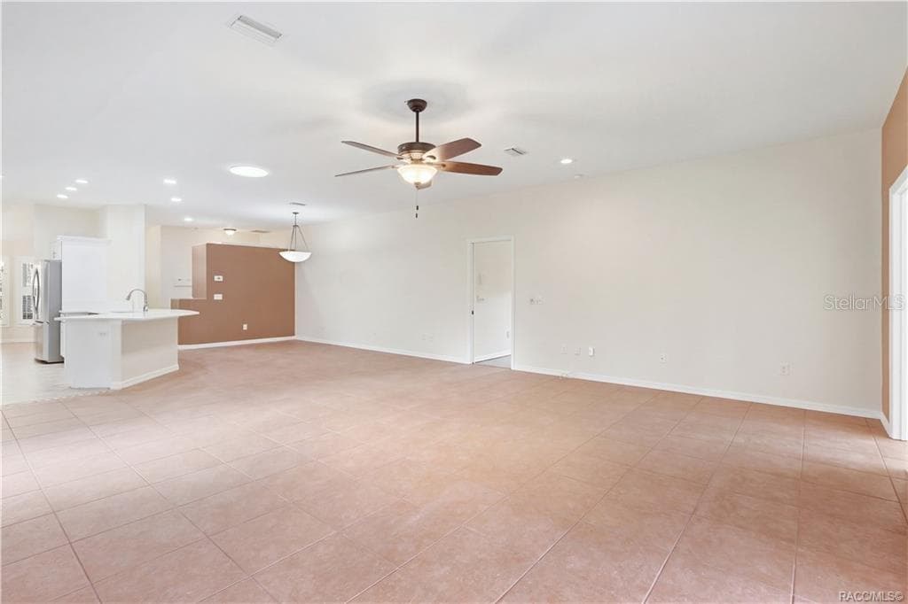Living Room TO KITCHEN – Spacious main living area flows directly into the kitchen & dining spaces, making the layout especially functional for everyday living or entertaining. Tile flooring continues throughout for a cohesive look. - 6410 W CANNONDALE DR, CRYSTAL RIVER