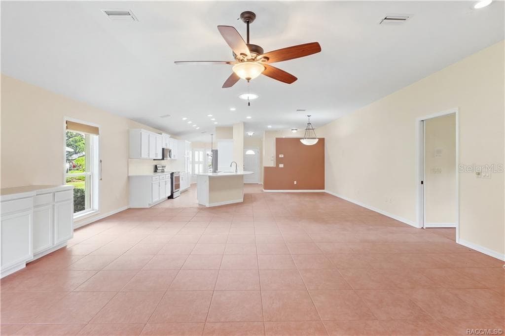 EXPANSIVE FLOOR PLAN – This view really captures the scale of the open living space, with ceiling fan, recessed lighting & uninterrupted sightlines toward the kitchen and front dining area. - 6410 W CANNONDALE DR, CRYSTAL RIVER