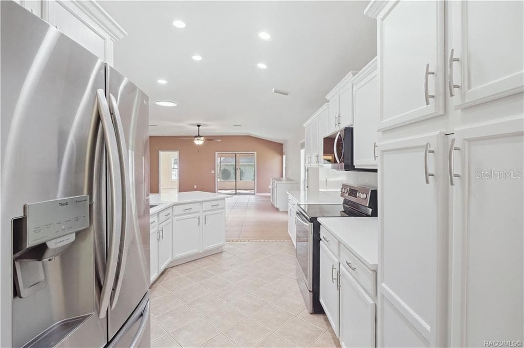 KITCHEN STORAGE & WORKSPACE – Excellent cabinet storage surrounds the kitchen, complemented by stainless-steel appliances, quartz countertops & generous workspace. The open configuration keeps the kitchen connected to the great room instead of tucked away. - 6410 W CANNONDALE DR, CRYSTAL RIVER