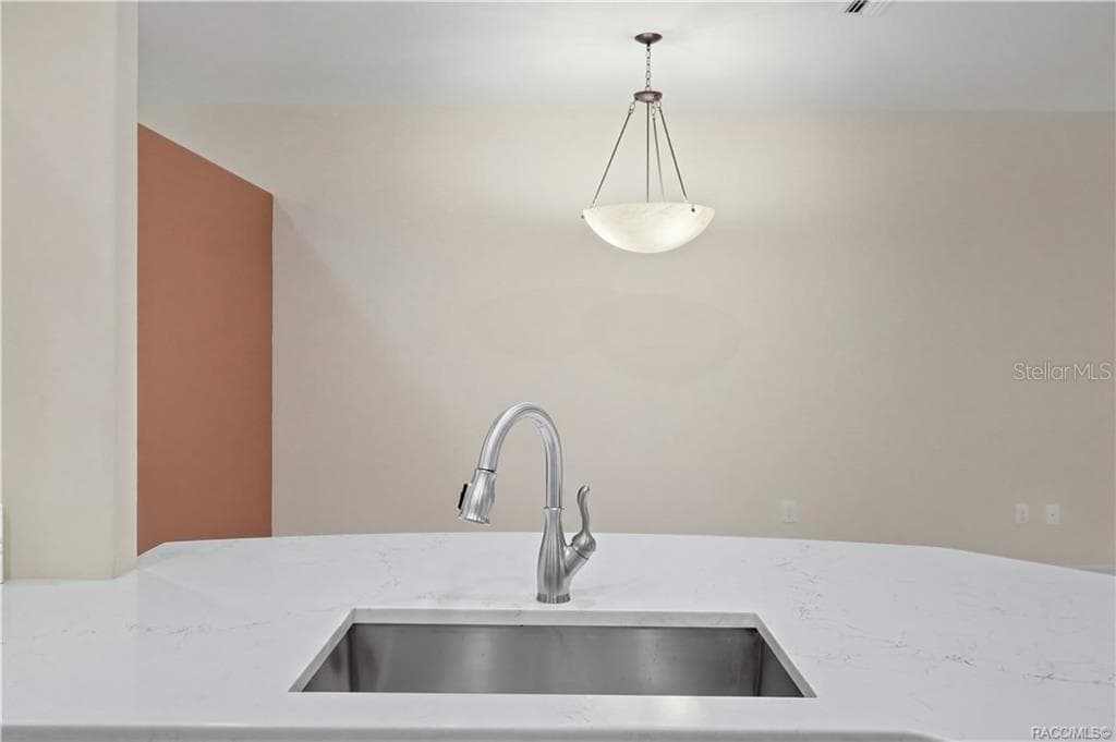 PENINSULA / SINK – Large quartz peninsula with an undermount stainless-steel sink & pull-down faucet creates a generous prep and serving area while maintaining an open view toward the adjoining living and dining spaces. - 6410 W CANNONDALE DR, CRYSTAL RIVER