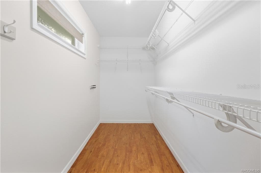 PRIMARY WALK-IN CLOSET – Generously sized walk-in closet with extensive wire shelving & hanging space on multiple walls, plus a window for natural light. - 6410 W CANNONDALE DR, CRYSTAL RIVER