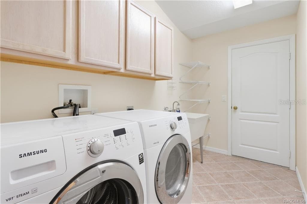 INDOOR LAUNDRY ROOM – Dedicated interior laundry room with washer & dryer, utility sink, upper cabinetry, additional wire shelving & tile flooring. - 6410 W CANNONDALE DR, CRYSTAL RIVER