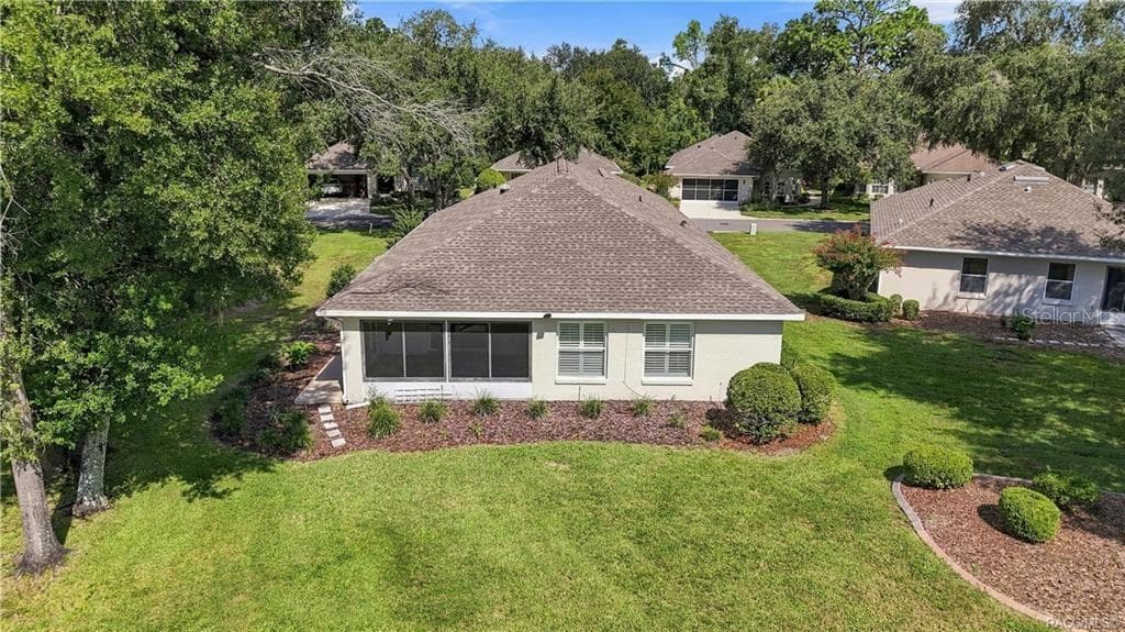 REAR EXTERIOR – Aerial rear view showcasing the home’s screened/enclosed rear living space, mature landscaping & generous green space surrounding the home. - 6410 W CANNONDALE DR, CRYSTAL RIVER