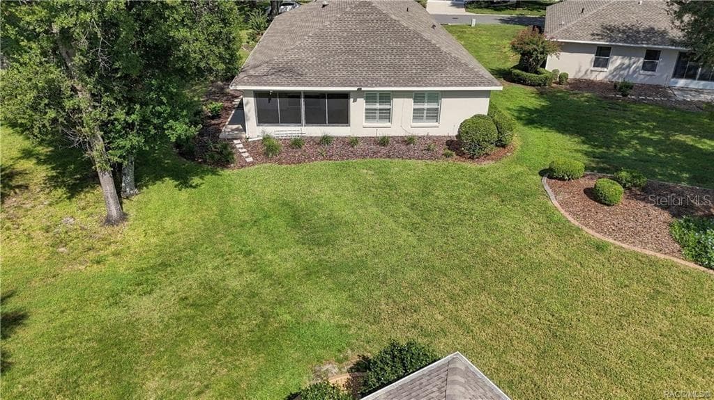 BACKYARD – Elevated view highlighting the spacious open backyard (common area), established trees, landscaped beds & rear exterior of the home. - 6410 W CANNONDALE DR, CRYSTAL RIVER