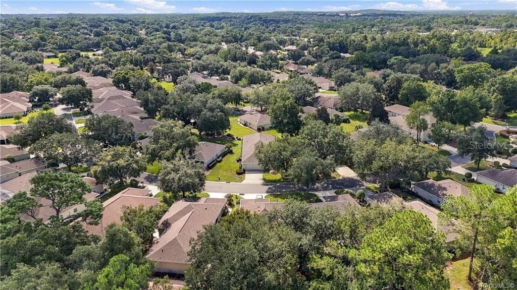 COMMUNITY AERIAL – Wide aerial perspective showcasing the home’s neighborhood setting with tree-lined streets, established homes & expansive surrounding greenery. - 6410 W CANNONDALE DR, CRYSTAL RIVER