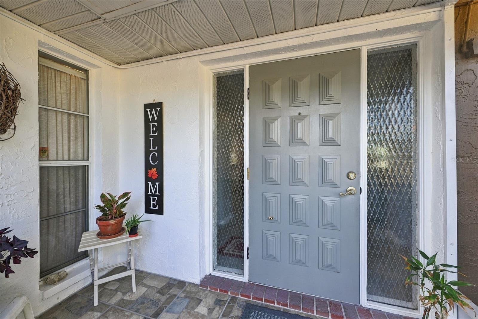 Screened front porch is and excellent area for plants and guests to get out of the weather. - 211 STONEHAM DR, SUN CITY CENTER