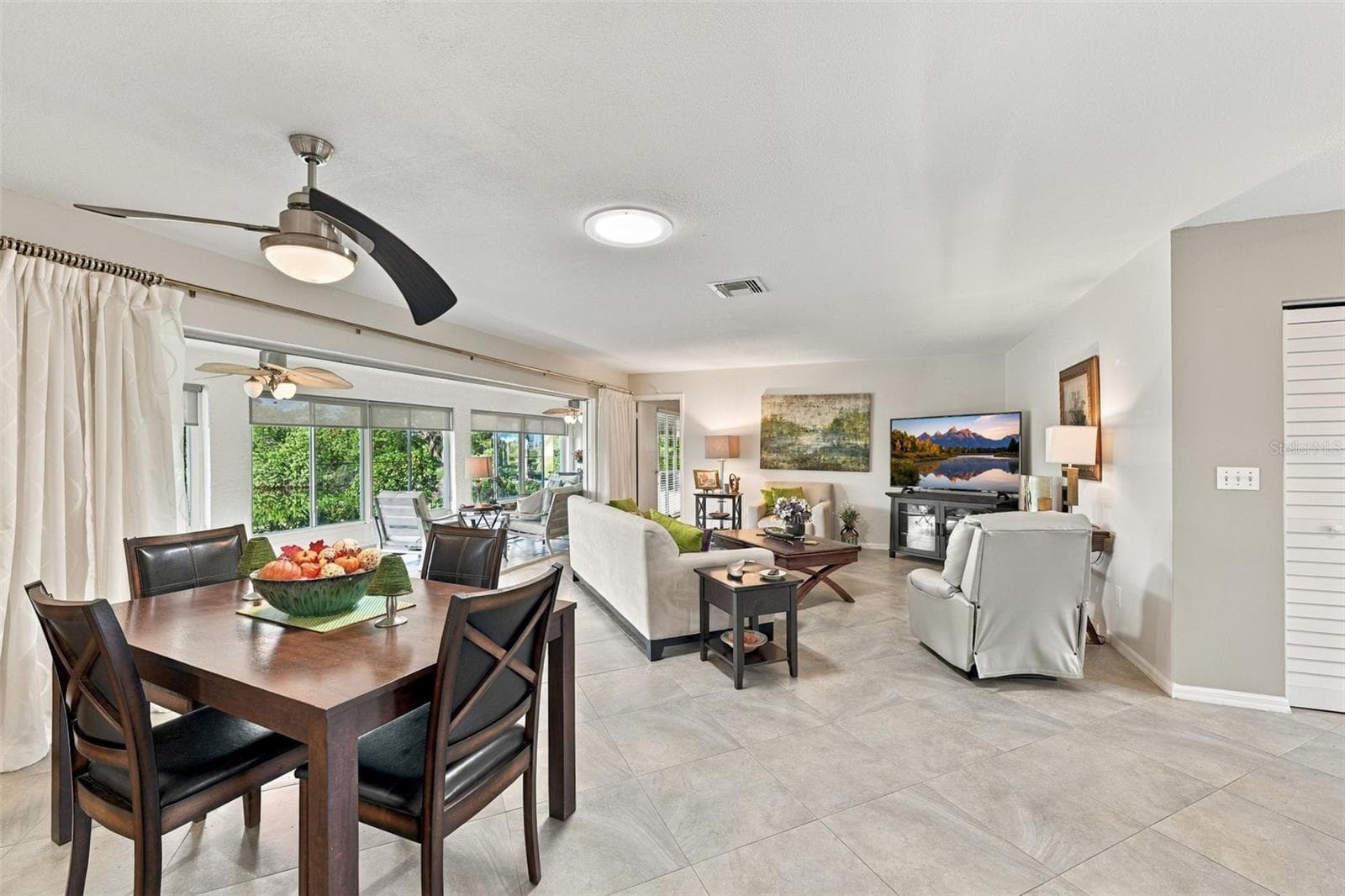 Beautiful tile flooring floats through out the open floor plan of the home, in a modern diagonal pattern. A large wall of windows brings in light, mother nature and a world of tranquility and peace. - 211 STONEHAM DR, SUN CITY CENTER