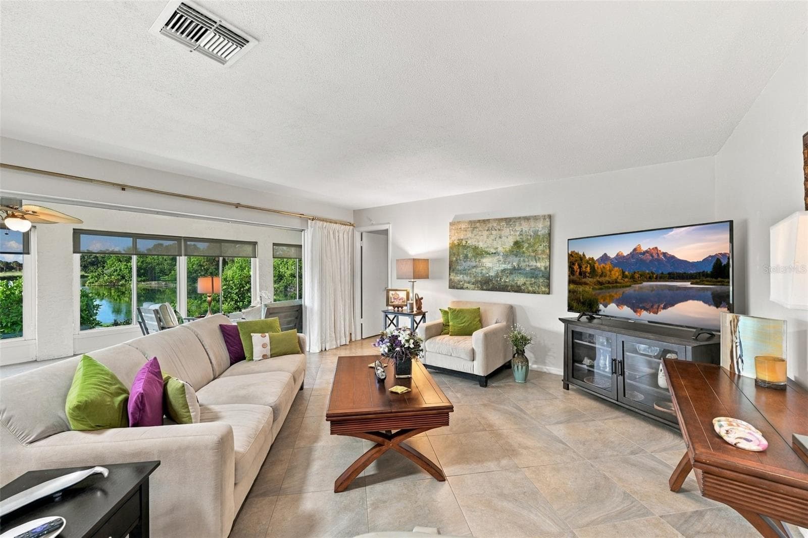 The great room opens right onto the Florida room, which has a wall of windows and sun shades. - 211 STONEHAM DR, SUN CITY CENTER