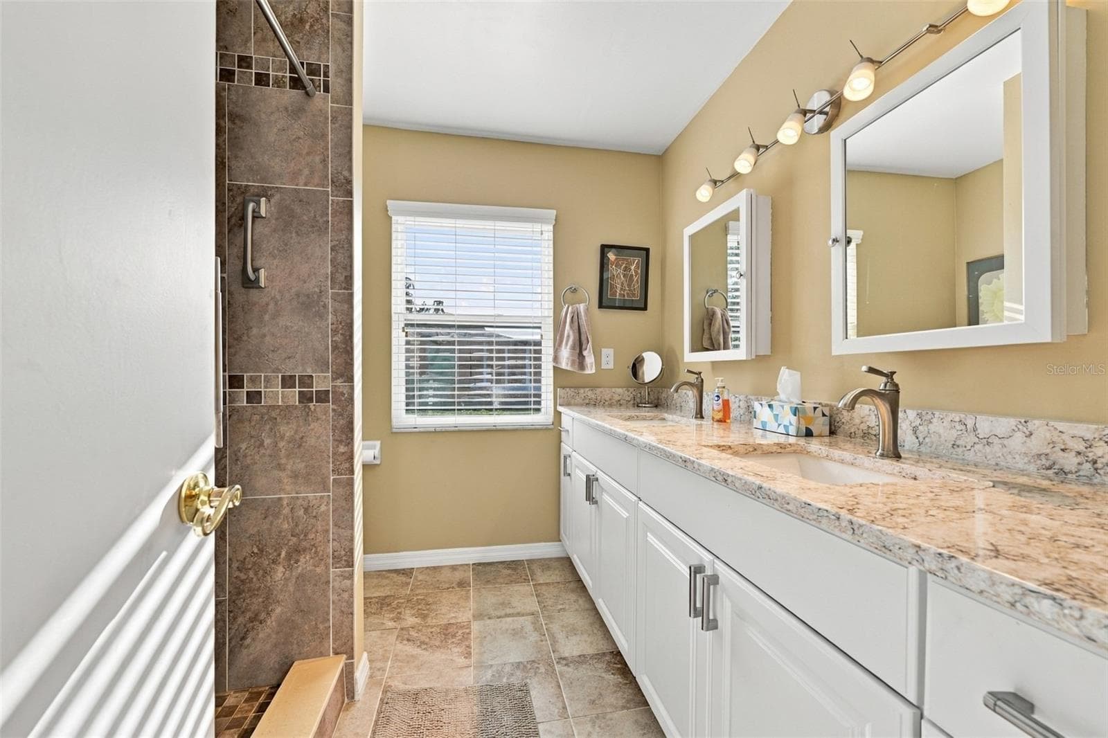 Guest bathroom is updated and modern with dual sinks, cabinetry and lovely tile work. - 211 STONEHAM DR, SUN CITY CENTER