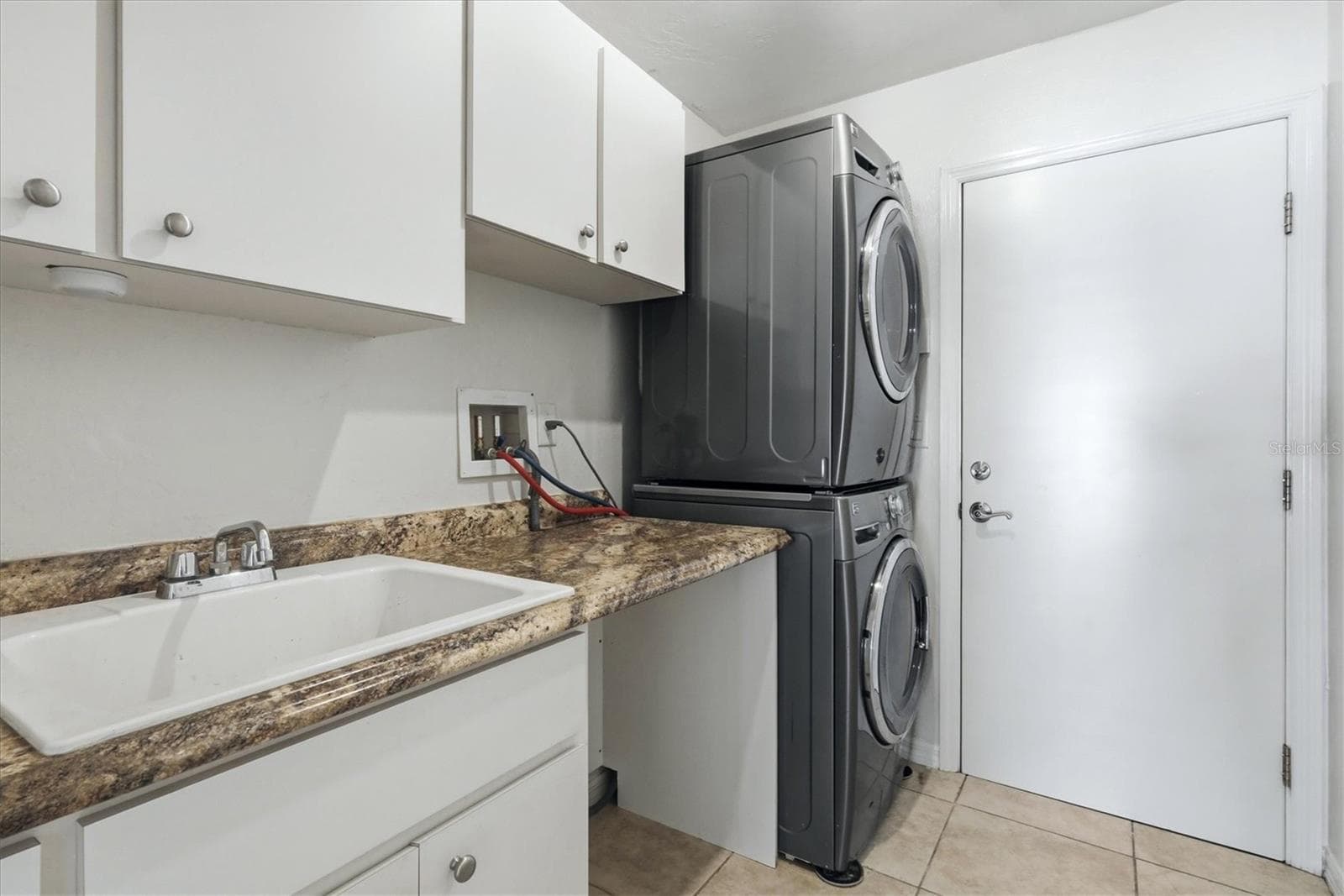 laundry with utility sink, stacked washer/dryer and plenty of cabinet space - 23108 AUGUST AVE, PORT CHARLOTTE