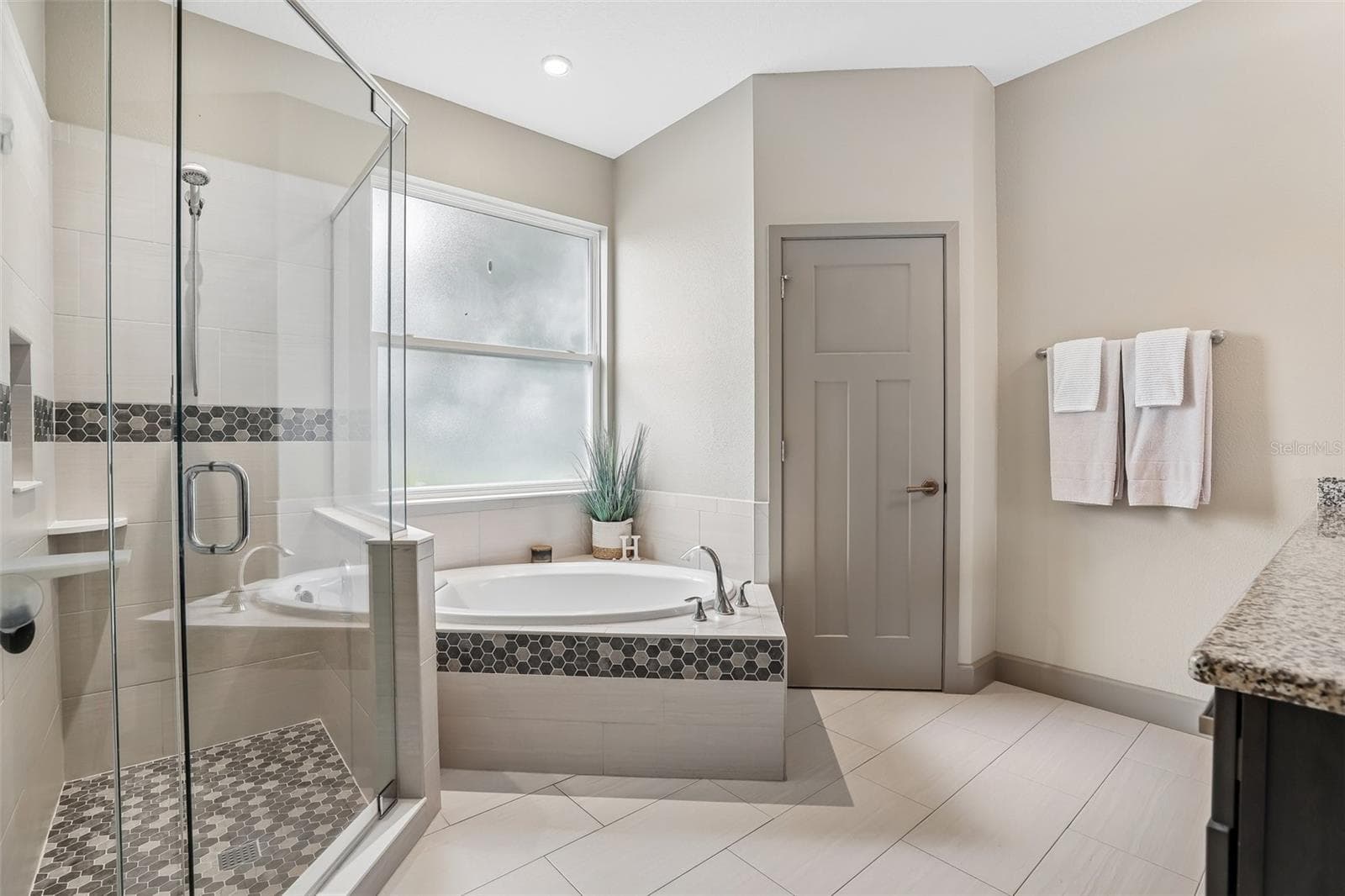 The Primary en suite Bath features dual sinks, a garden tub, step-in shower and private water closet. - 19179 SABAL ST, ORLANDO
