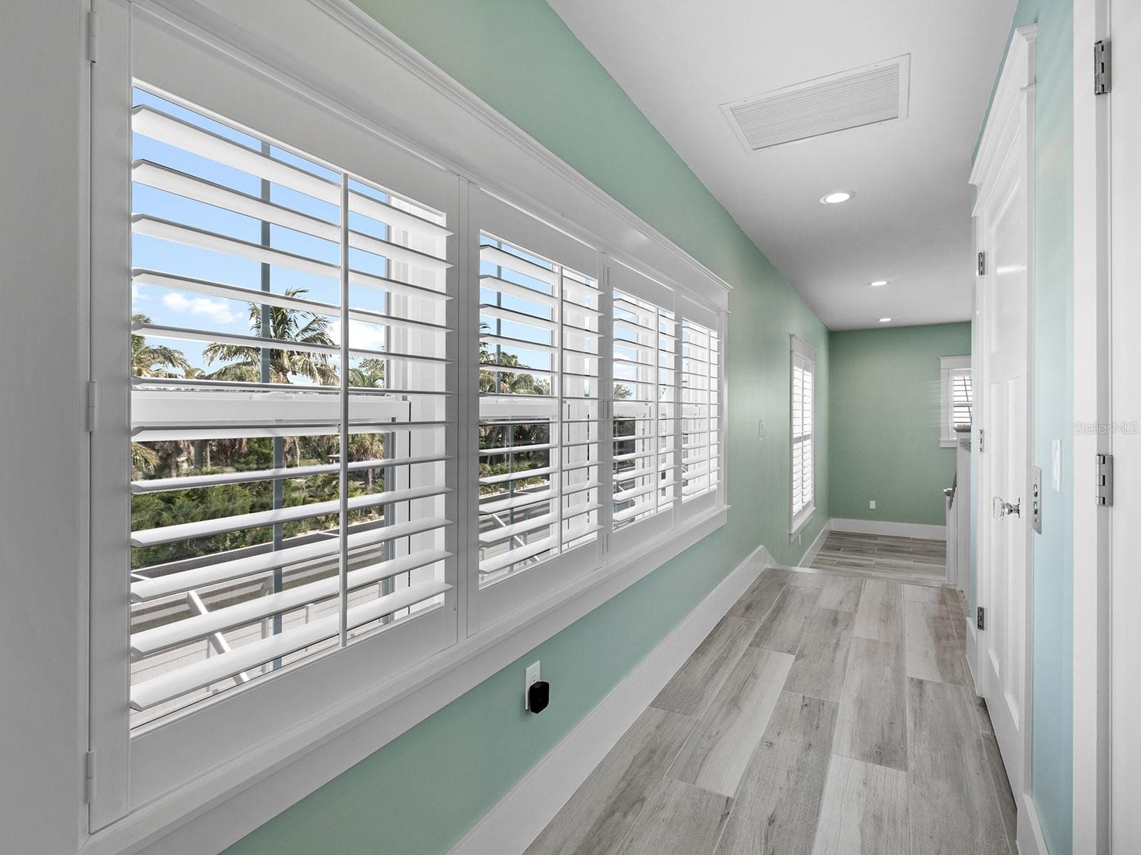 Hallway from the den and primary suite with elevator on right - 4024 11TH STREET CT W, PALMETTO