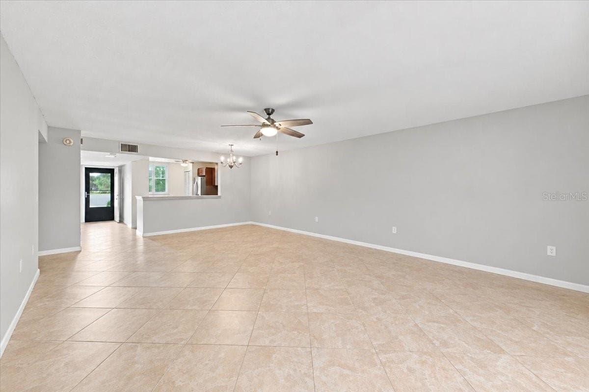 Dining and living room area looking toward kitchen and front door - 411 PALM TREE DR #411, BRADENTON