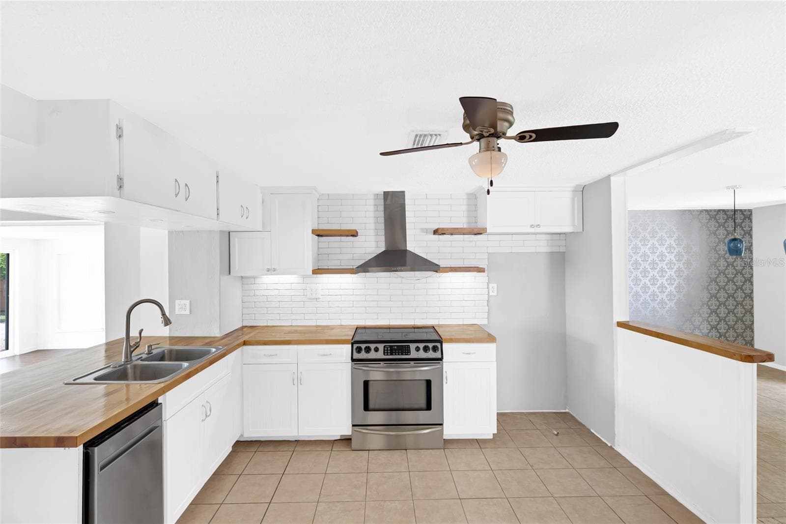A stainless steel range and vent hood anchor the kitchen, with generous counter space for cooking and entertaining. - 142 2ND AVE, NOKOMIS