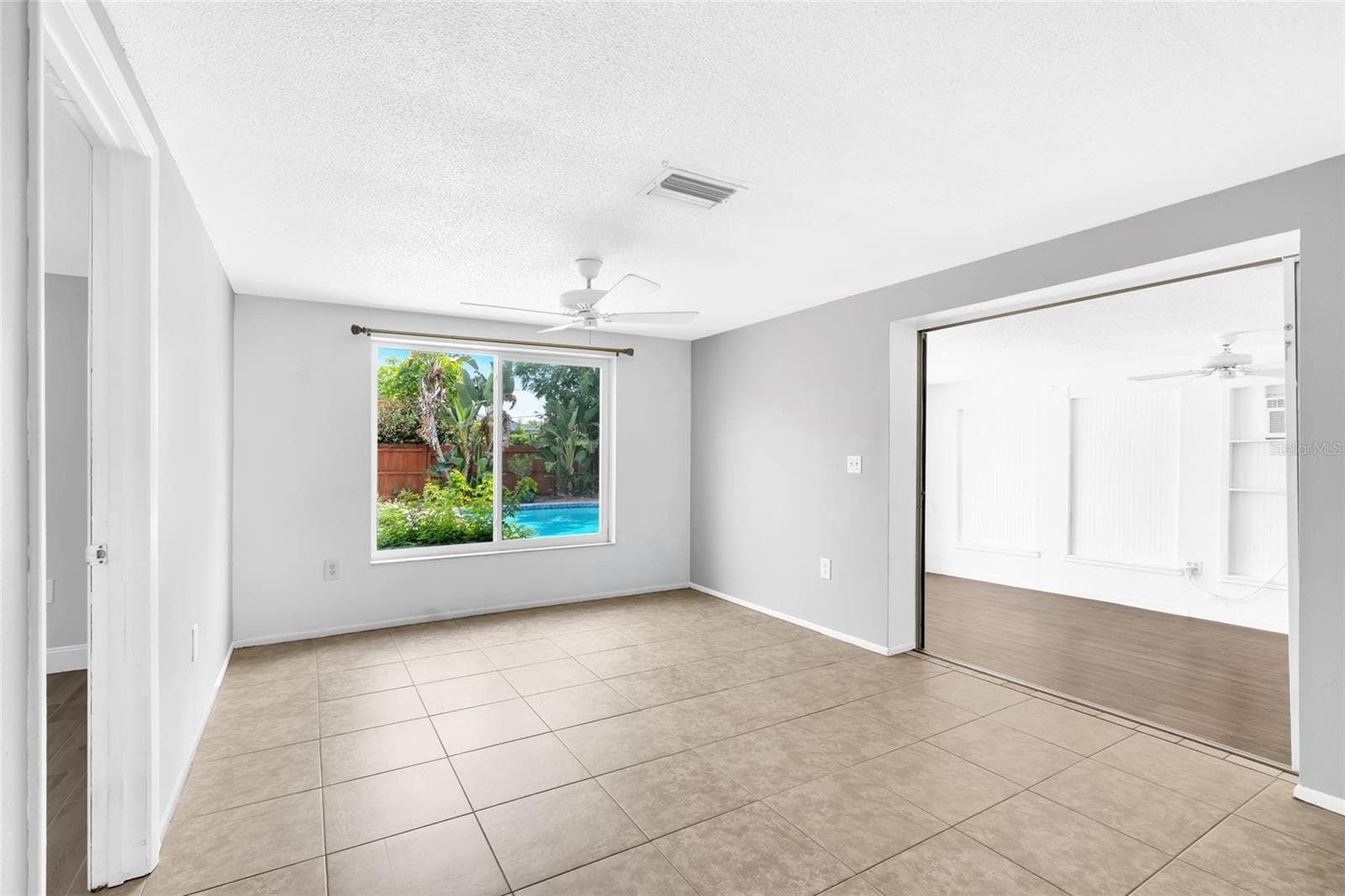The family room offers a true second living space with a large picture window overlooking the private pool and tropical backyard. - 142 2ND AVE, NOKOMIS