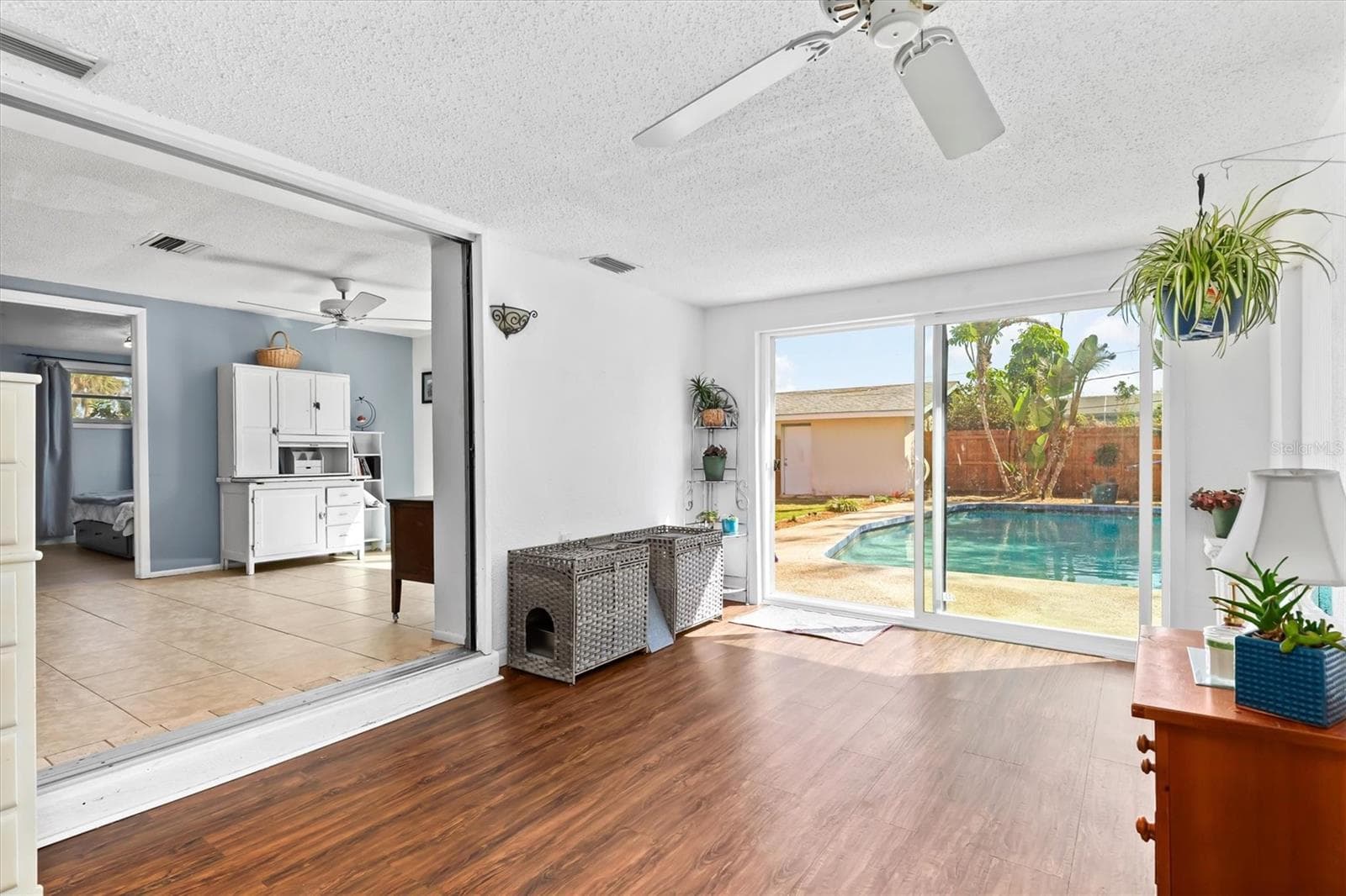 The bonus room expands the home’s living space and offers a flexible setting for a home office, hobby room, reading area or additional lounge space, with the pool and tropical backyard just outside. Photo taken during prior occupancy. - 142 2ND AVE, NOKOMIS
