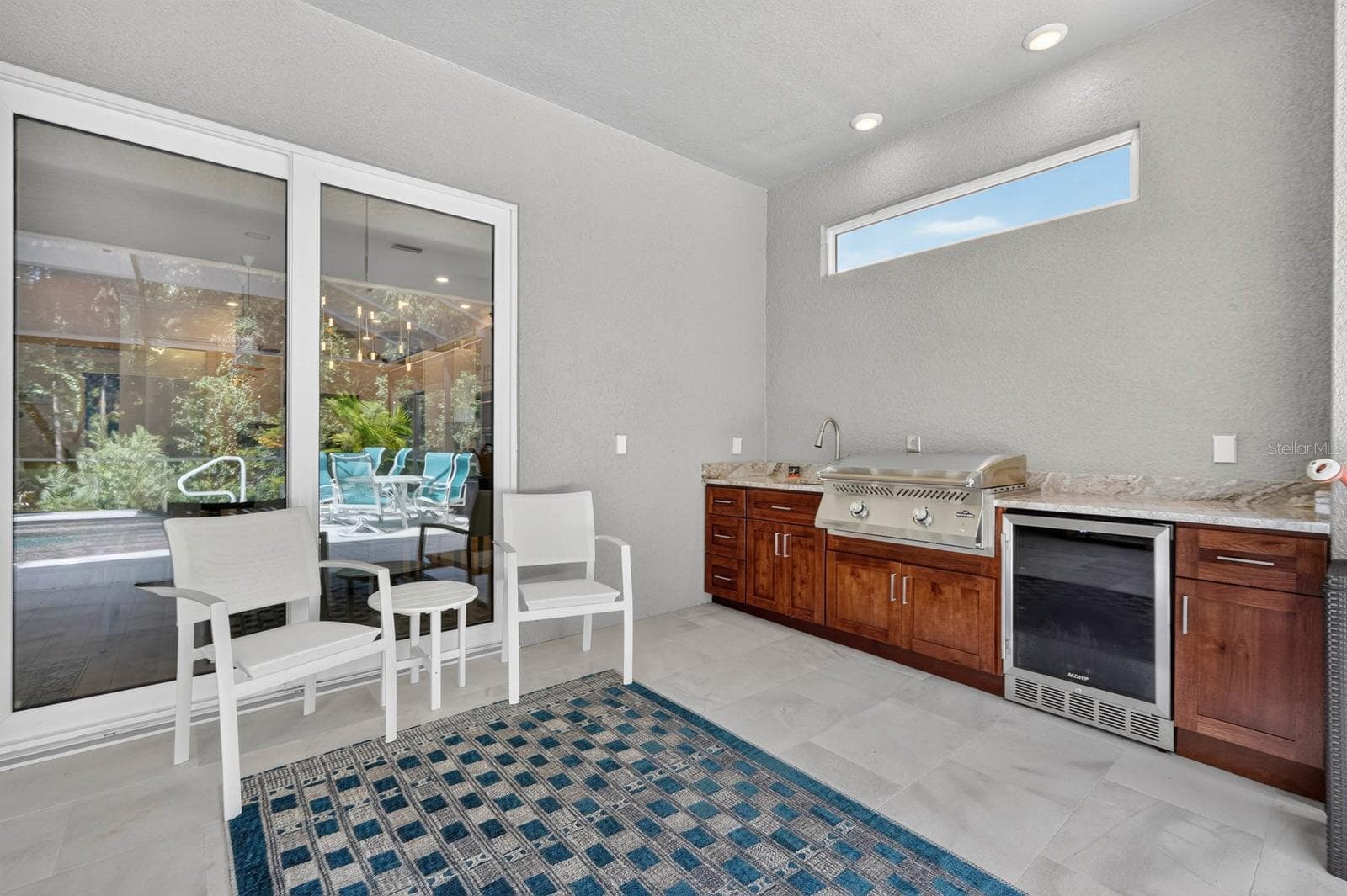 Outdoor kitchen features beautiful soft close cabinetry, granite counters and outdoor fridge and grill plus sink - 36 NEW WATER OAK DR, PALM COAST