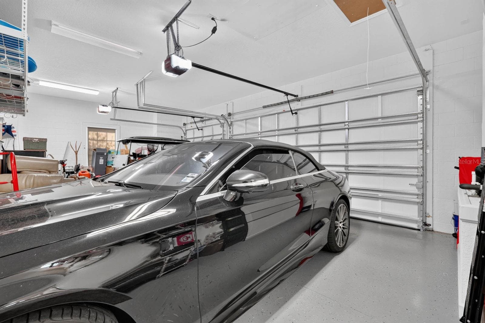 3 car garage with coated painted floor, electronic storage lift for attic and additional storage shelving. - 36 NEW WATER OAK DR, PALM COAST