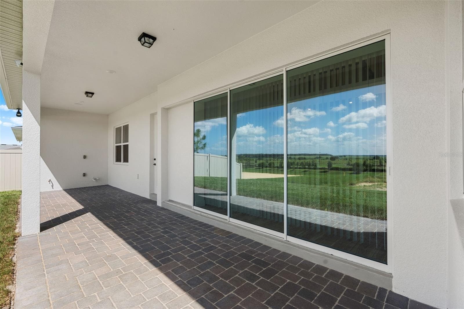 Triple sliding glass doors open up to a paver lanai. - 4617 GOLDEN BIRCH AVE, CLERMONT