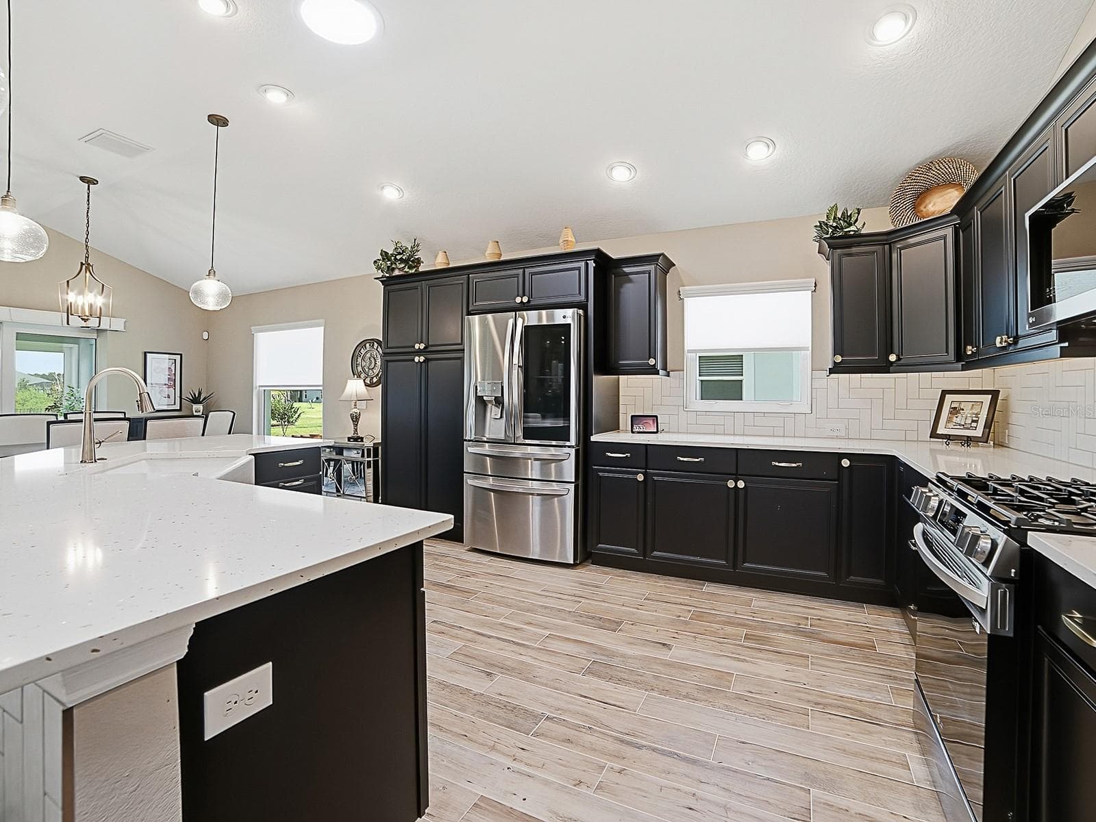 WHAT A BEAUTIFUL KITCHEN! QUARTZ COUNTERTOPS, STAINLESS APPLIANCES, CUSTOM CHAMPAGNE BRONZE HARDWARE, UPPER AND LOWER PULL OUT DRAWERS IN LOWER CABINETS. - 3075 LICCIARDELLO PATH, THE VILLAGES