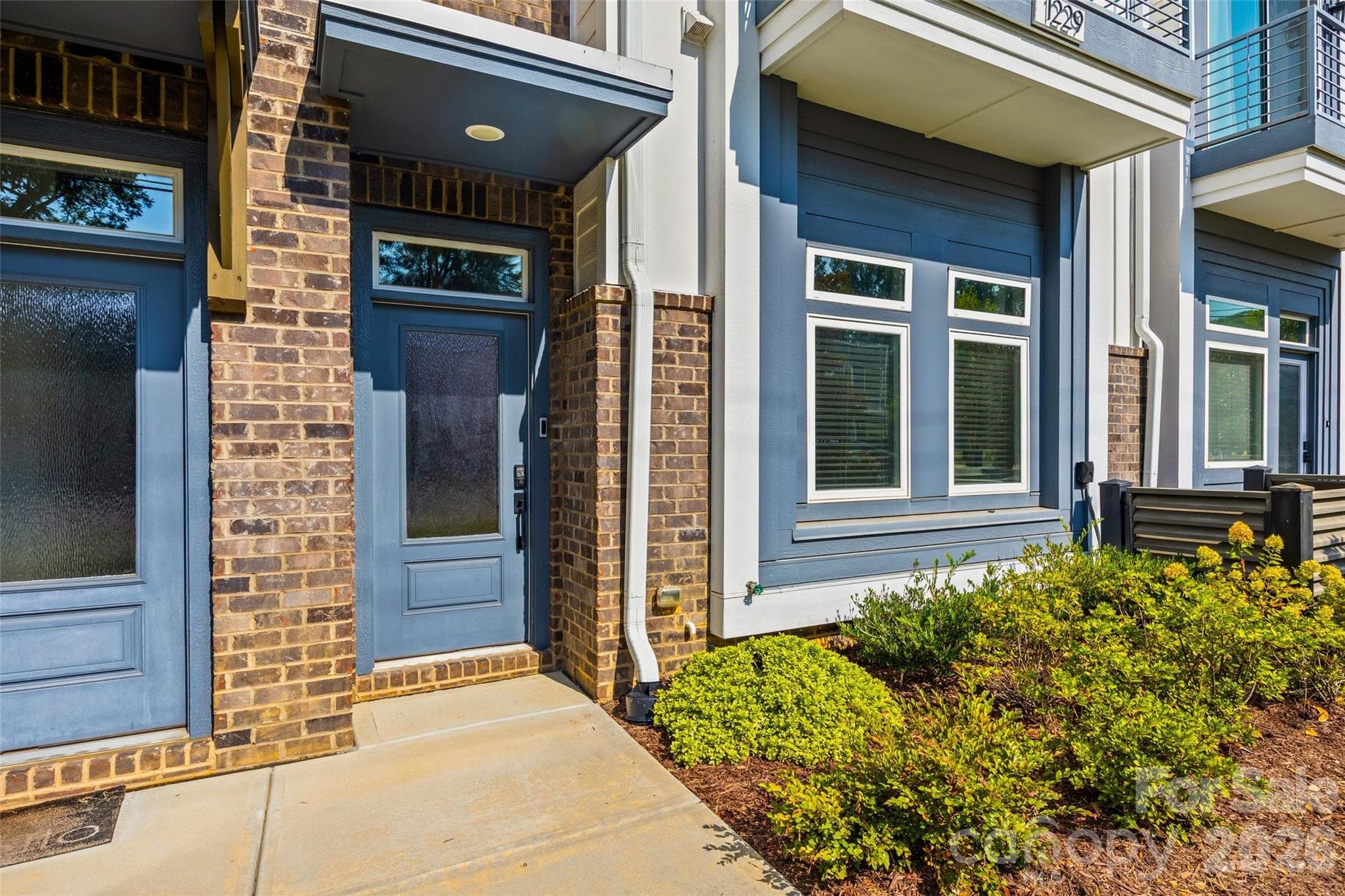 Welcoming front entry with brick and contrasting blue siding - 1229 Lomax Avenue, Charlotte