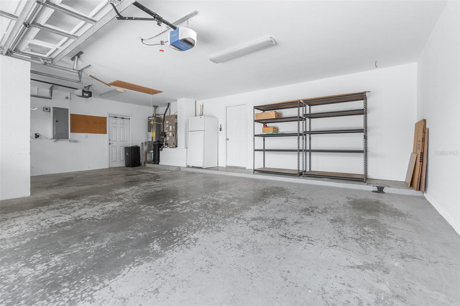 Large 3-car garage with storage space and extra fridge - 27015 FIREBUSH DR, WESLEY CHAPEL