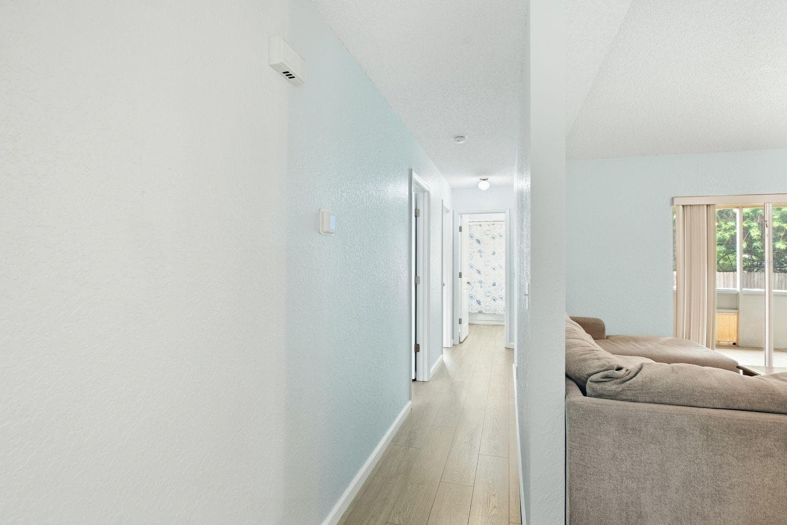 Hallway to 2 bedrooms, 1 full bathroom and additional door to back patio and pool area. - 5955 107TH TER N, PINELLAS PARK