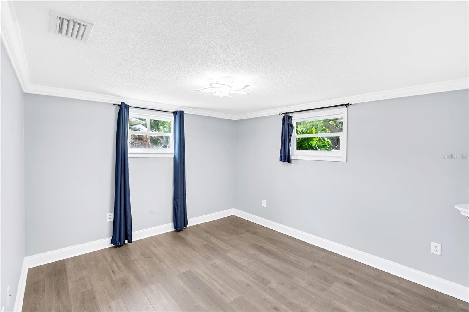 Two windows bring natural light into Bedroom 2, while updated flooring and generous proportions leave plenty of flexibility for furniture placement. - 142 2ND AVE, NOKOMIS