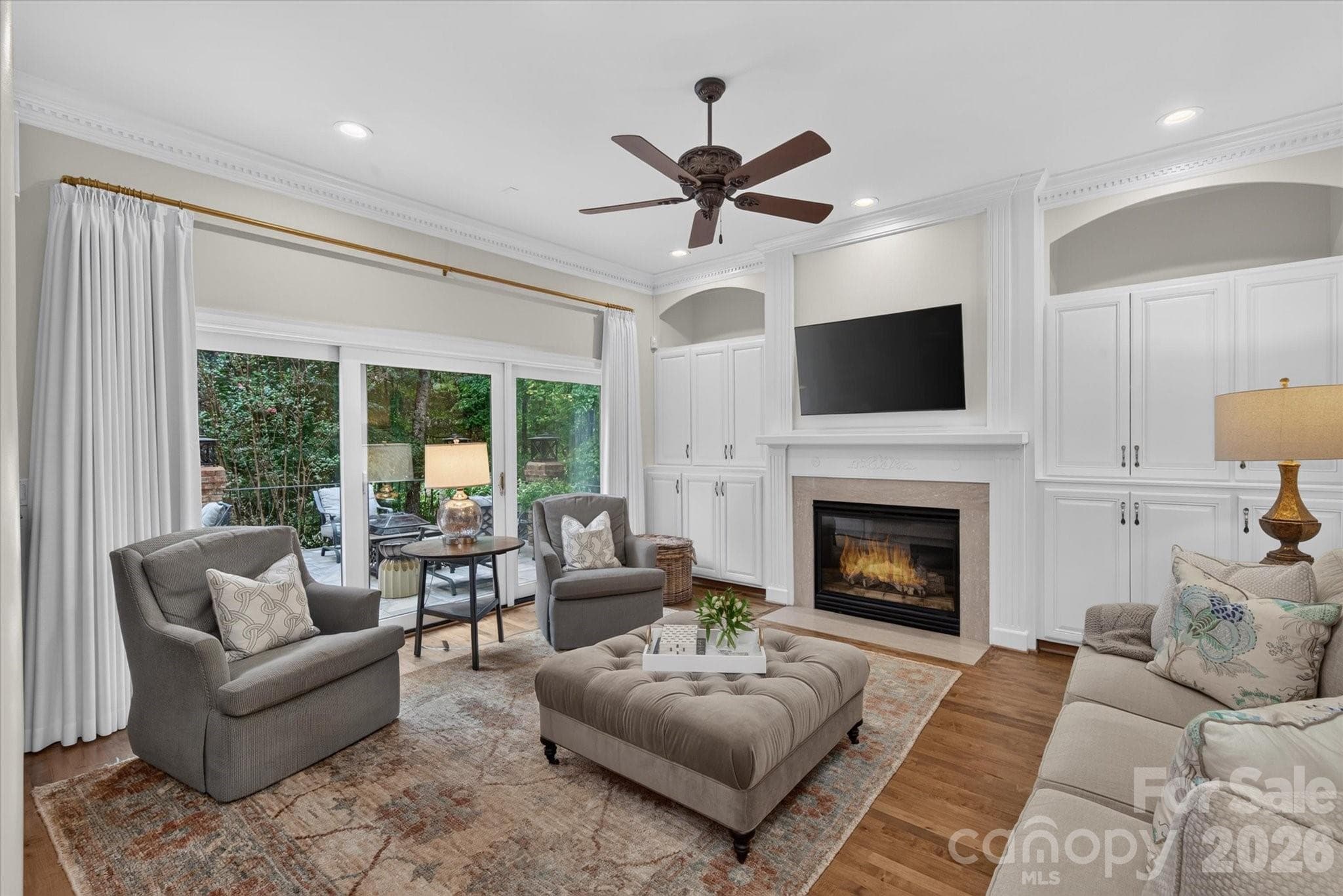Built-ins flank the fireplace and glass doors lead to an open terrace - 1005 Firethorne Club Drive, Marvin