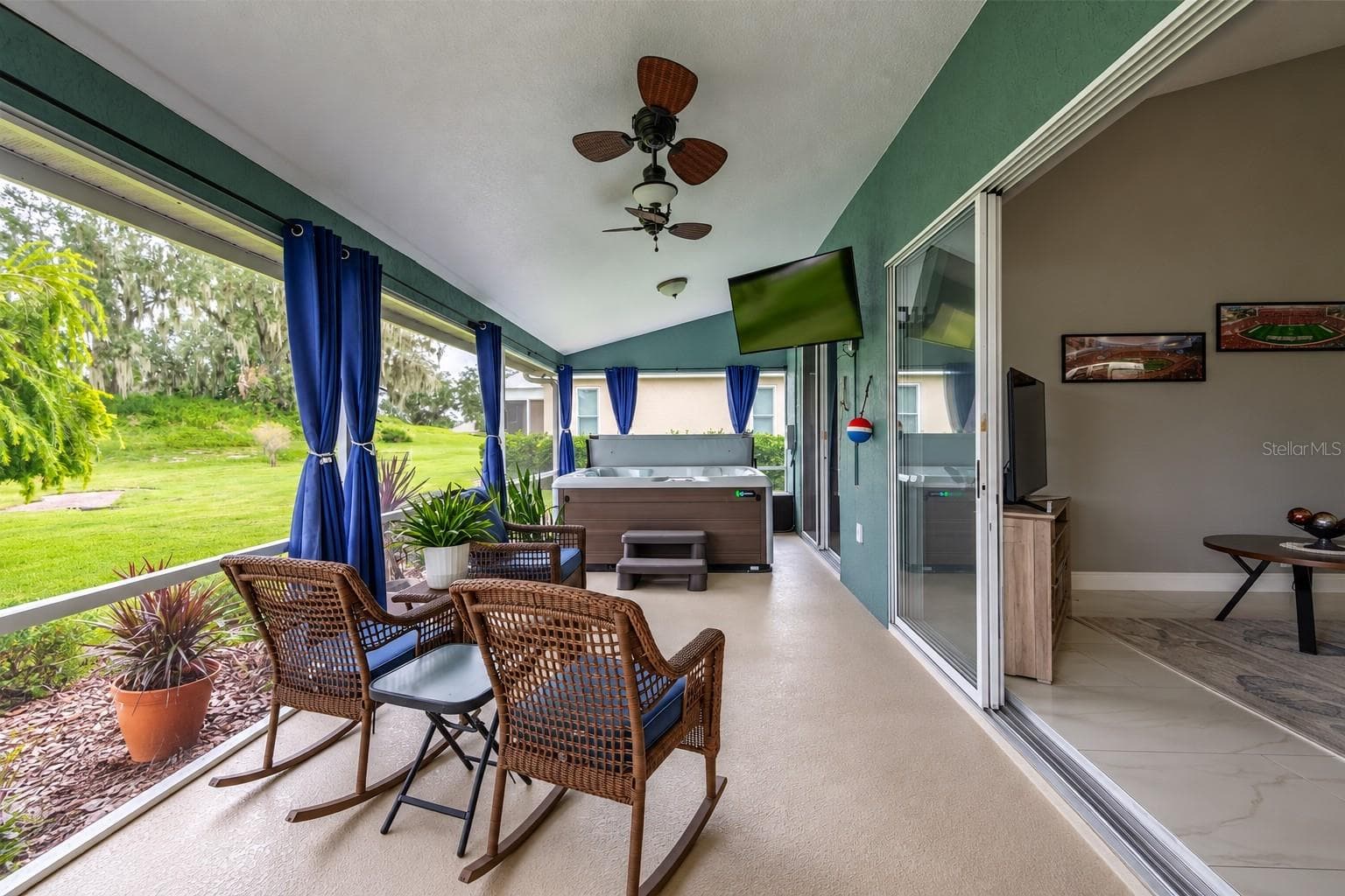 Spacious screened lanai just off the great room, featuring a relaxing seating area, outdoor TV and hot tub. - 4465 FAIRWAY OAKS DR, MULBERRY