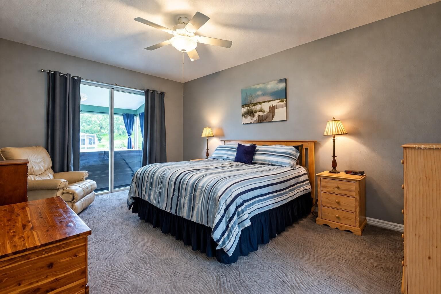 Primary bedroom with sliders to the lanai and hot tub. - 4465 FAIRWAY OAKS DR, MULBERRY