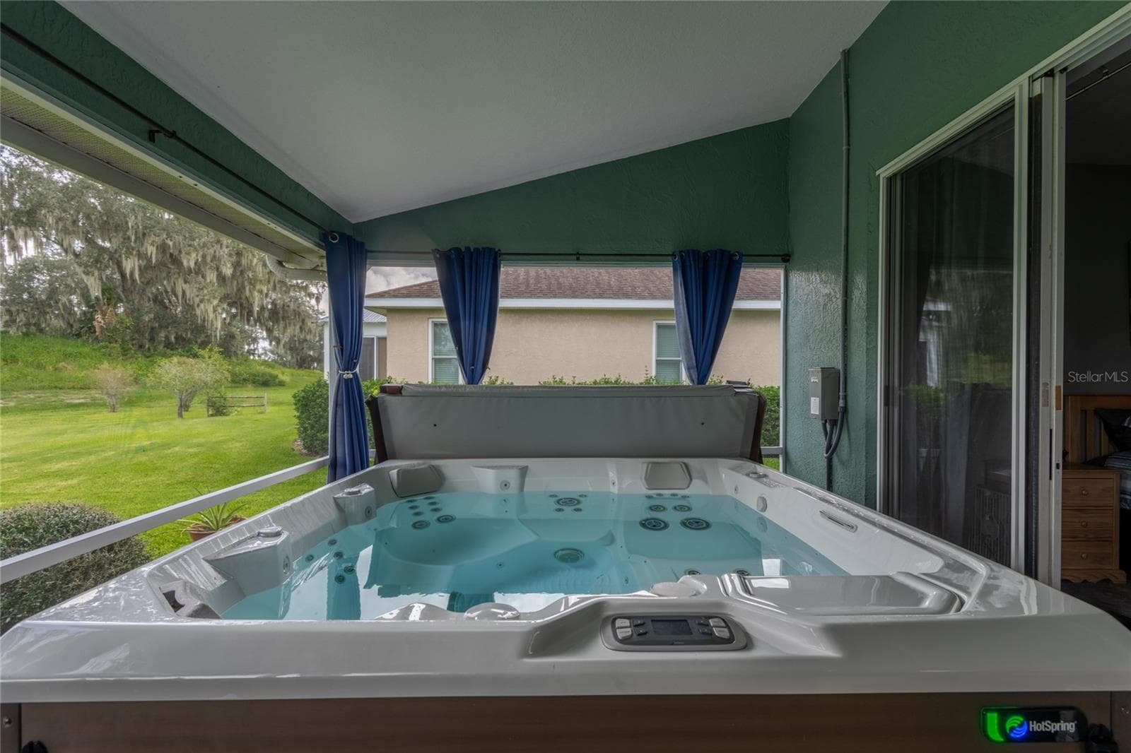 Located off the primary bedroom is a 2-year-old hot tub with curtains to close for privacy. - 4465 FAIRWAY OAKS DR, MULBERRY