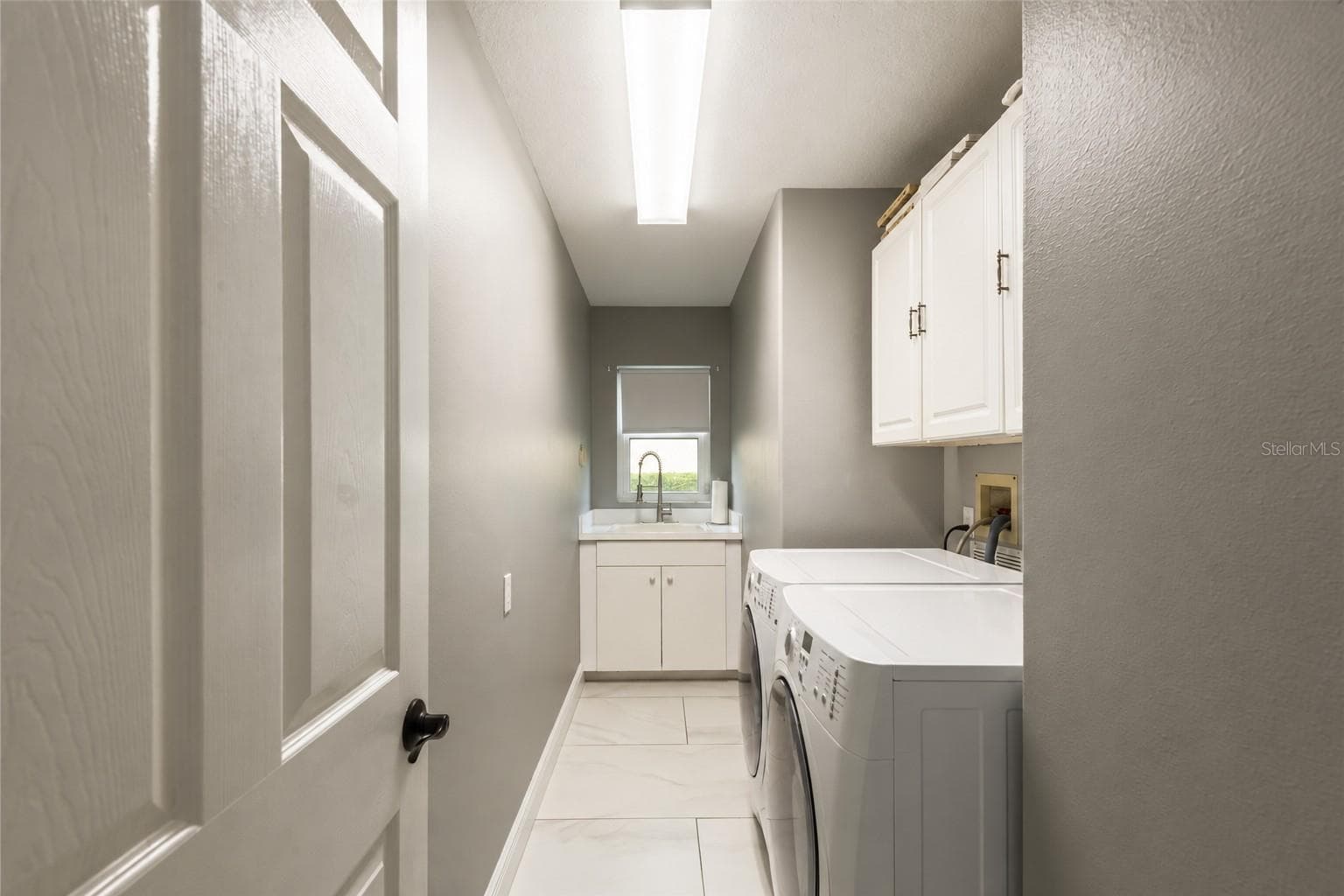 Laundry room with storage and sink. - 4465 FAIRWAY OAKS DR, MULBERRY