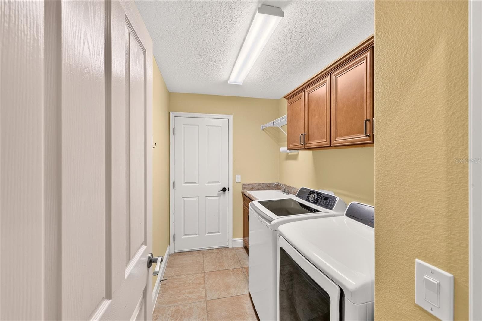 Inside Laundry Room with Utility Sink, Cabinets & Washer/Dryer - 2084 NORDIC LN, THE VILLAGES