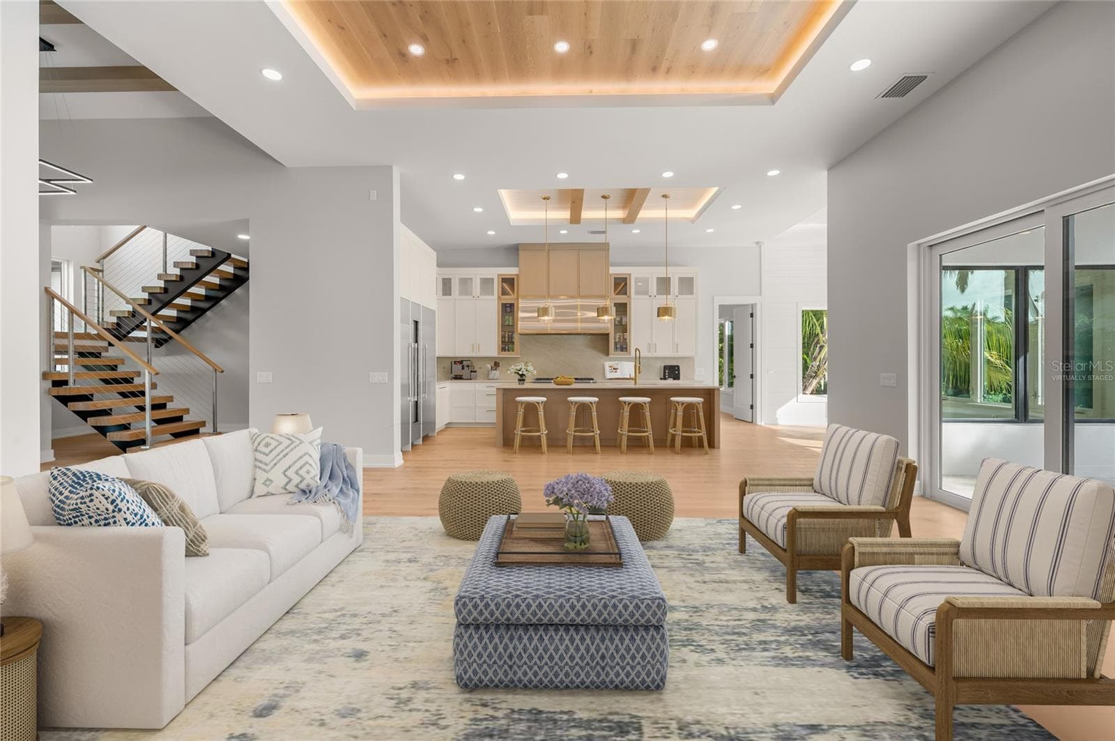 Virtually staged family room featuring a custom inlaid wood ceiling, flowing seamlessly into the kitchen and dining area. - 3360 BAYOU SOUND, LONGBOAT KEY