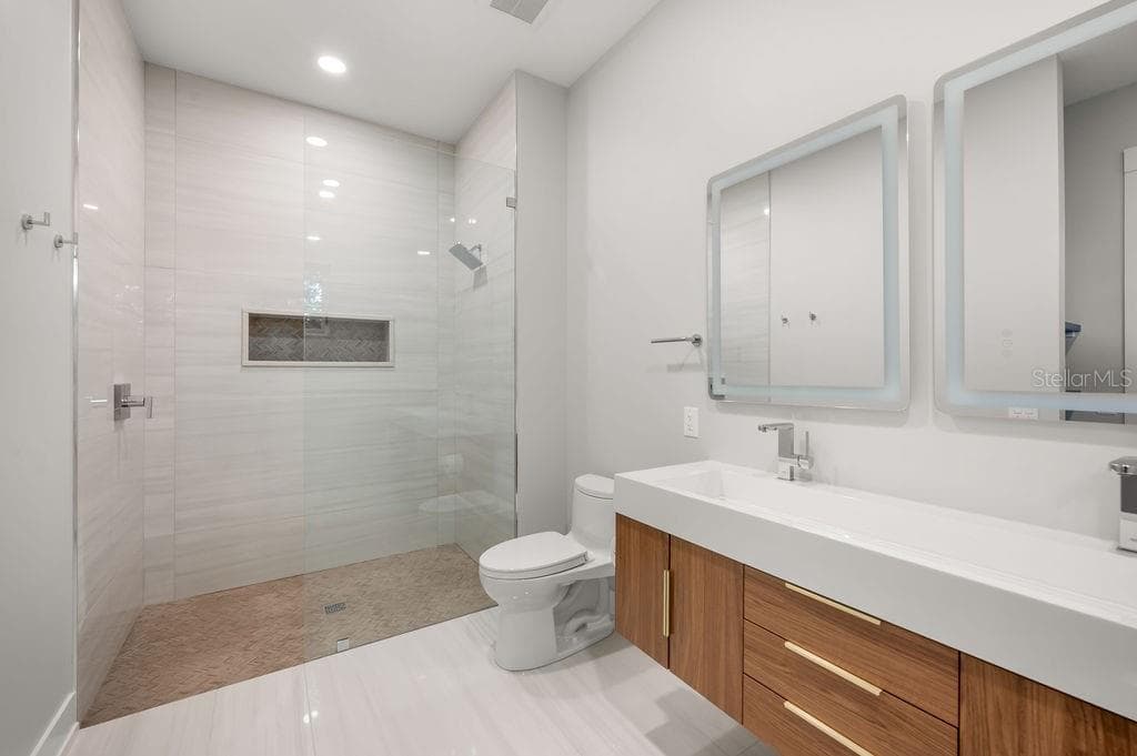 Beautifully designed guest bath featuring custom tile work and sophisticated finishes. - 3360 BAYOU SOUND, LONGBOAT KEY