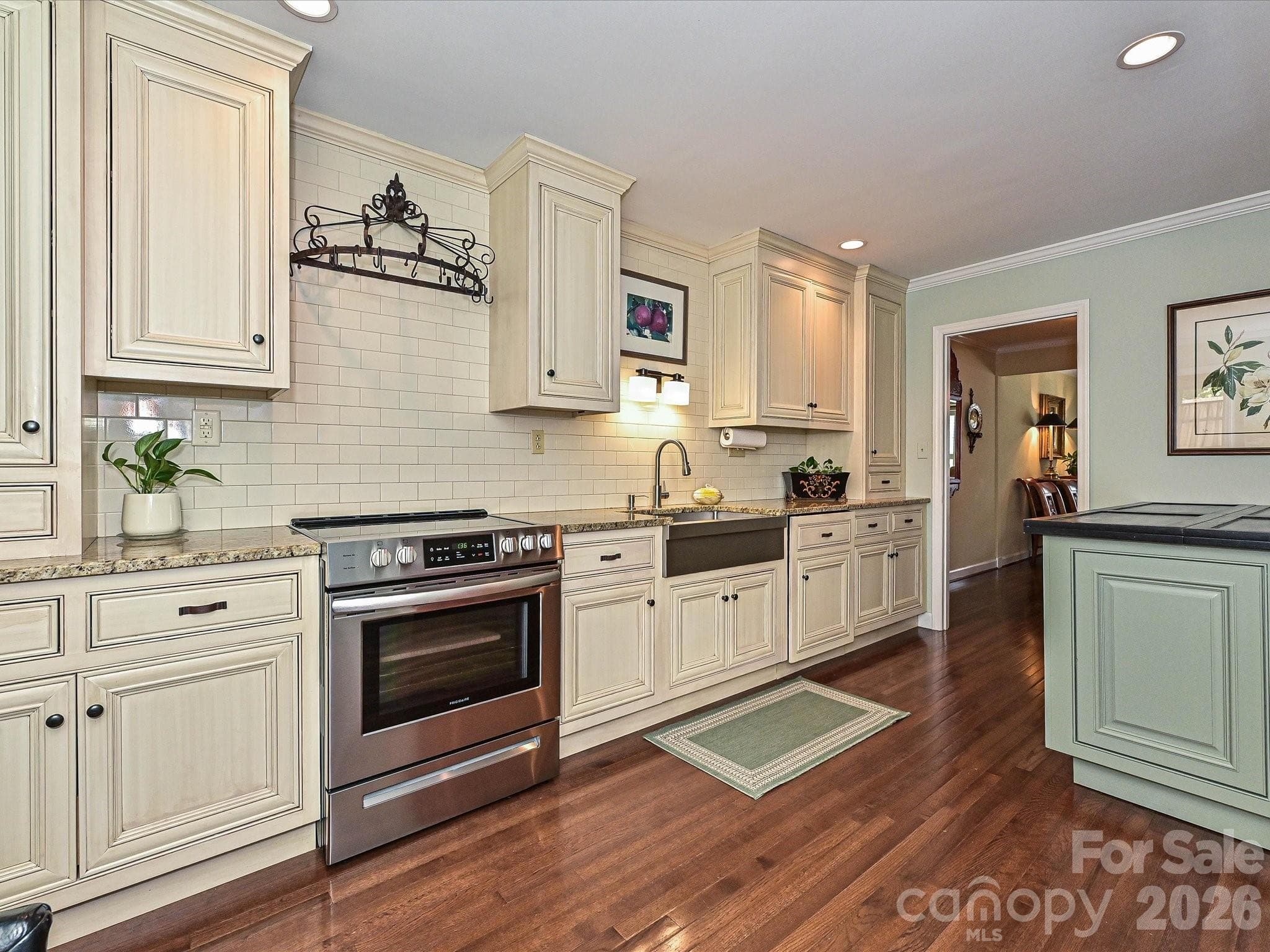 Updated kitchen with granite counter top, subway tile backsplash, stainless farm sink and newer stove. - 4313 Silo Lane, Charlotte