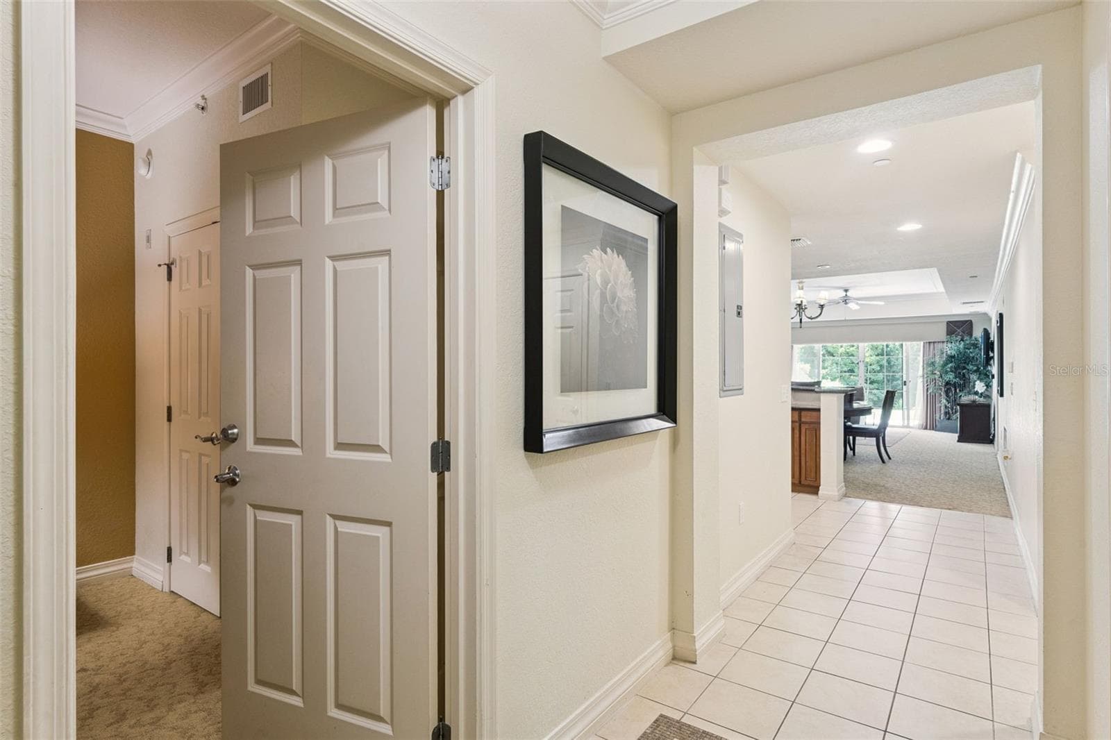 Entry Foyer: Welcoming entryway featuring neutral tile flooring, crisp trim work, and direct sightlines into the open-concept living area. - 7656 WHISPER WAY #102, REUNION