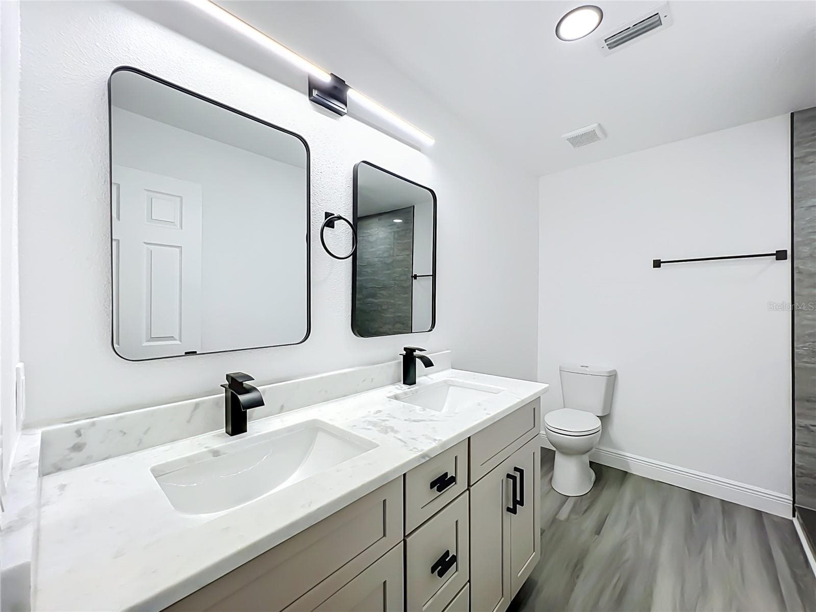 Beautifully updated bathroom featuring double vanity and modern finishes. - 5610 SHASTA DR, ORLANDO